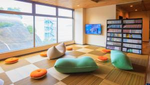 a library with green and orange chairs on the floor at Livemax Resort Mihara Onsen Seafront in Mihara