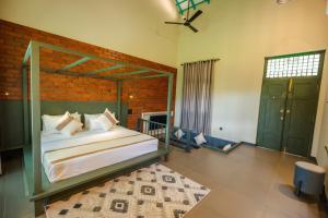 a bedroom with a large bed and a brick wall at Cape Sigiriya in Sigiriya +35 photos