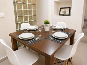a dining room with a wooden table and white chairs at Apartamento Cuzco in Trujillo +25 photos
