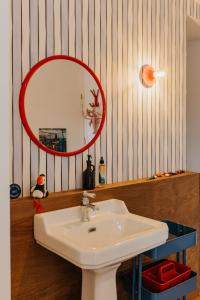 a bathroom with a sink and a red mirror at Les Ecuries du bout du monde in Landunvez