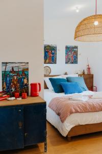 a bedroom with a bed with blue pillows at Les Ecuries du bout du monde in Landunvez