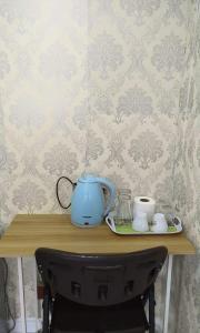 a table with a tea kettle and cups on it at Breeze Homestay in Nong Khai