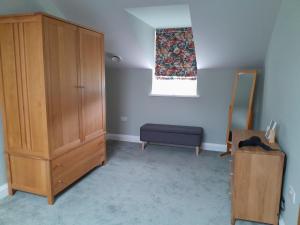 a bedroom with a wooden cabinet and a blue chair at The Old Saw Mill in Llangunllo