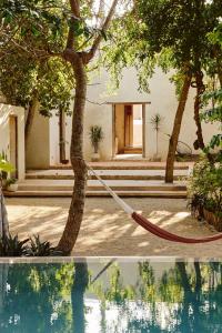 a hose tied to a tree next to a house at Casona los Cedros in Espita