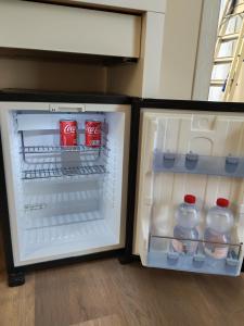 an open refrigerator with bottles of cocacola at B&B Il Dolce Castello di Balestrino in Balestrino