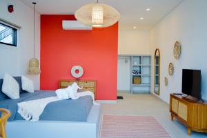 a bedroom with a blue bed and a red wall at Villa Mercure. Private villa. 2 en-suite bedrooms. in Amed