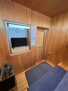 a small room with a tv and a window at Hotel Cradle Cabin Tateyama in Tateyama