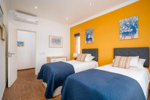 two beds in a room with yellow walls at Dois Moinhos Do Vento, Santo Estevão in Santo Estêvão +110 photos