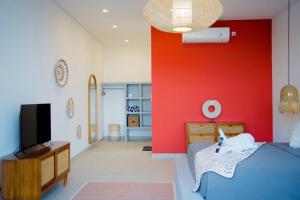 a bedroom with a blue bed and a red wall at Villa Mercure. Private villa. 2 en-suite bedrooms. in Amed +23 photos