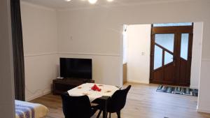 a living room with a table and chairs and a television at Matei tiny house in Grinţieşu Mic