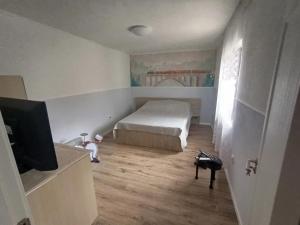 a bedroom with a bed and a flat screen tv at Matei tiny house in Grinţieşu Mic