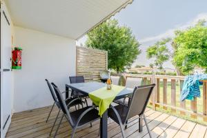 a dining room with a table and chairs on a deck at 11 - Le Rossignol - Village vacances in Maché