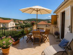 a patio with a table and an umbrella on a balcony at Inter-nautika doo in Jezera