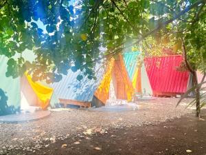 a group of colorful buildings with trees in the foreground at Fresh Beach Resort in Cateel +5 photos