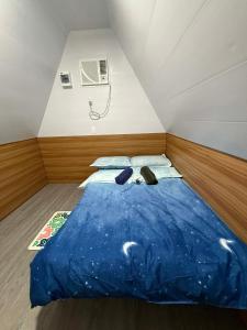 a small room with a blue bed in a attic at Fresh Beach Resort in Cateel