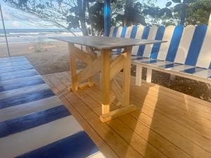 a picnic table and chairs on a deck near the beach at Fresh Beach Resort in Cateel