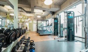 a gym with rows of treadmills and machines at HOTEL APART - Welcoming l Urban Feel l Design in Rotkreuz