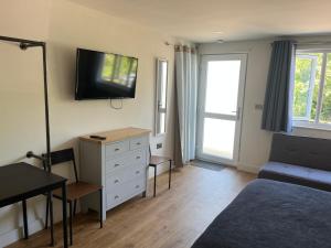 a bedroom with a bed and a tv on the wall at Green haven in Winford
