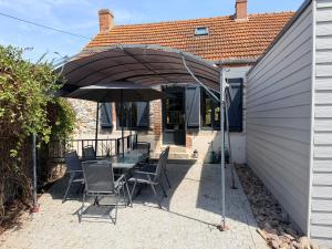 a patio with a table and an umbrella at Chez Mémé Cécile in Montluçon