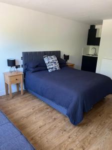 a bedroom with a large bed with a blue blanket at Green haven in Winford