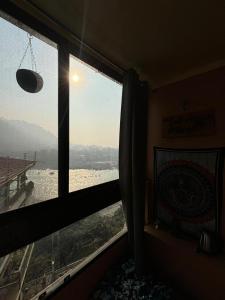 a room with a window with a view of the ocean at Om Guesthouse in Rishīkesh