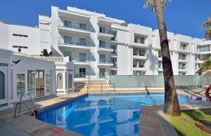 a swimming pool in front of a white building at SOL by Meliá Torremolinos Don Marco - Adults Recommended in Torremolinos