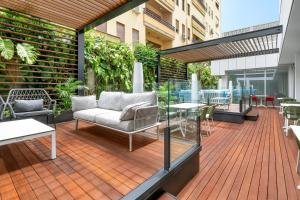 a wooden deck with chairs and tables on a building at SOL by Meliá Torremolinos Don Marco - Adults Recommended in Torremolinos