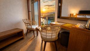 ein Zimmer mit Schreibtisch, Stühlen und Fenster in der Unterkunft Qinn Hotels in Antalya