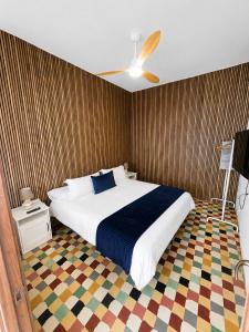 a bedroom with a large bed and a ceiling fan at Oasis Noalys in Sardina