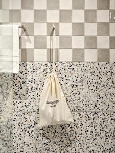 a white bag hanging on a tiled floor at Folk Copenhagen in Copenhagen +26 photos