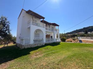 a large white house with a large yard at Explorer's Rest in Argassi