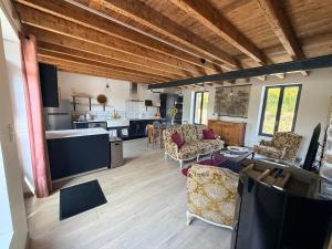 a living room with couches and a kitchen at Chez Mémé Cécile in Montluçon