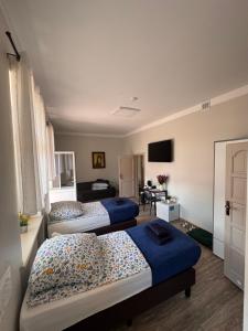a bedroom with two beds and a television in it at Pałac pod Bocianim Gniazdem in Runowo +161 photos