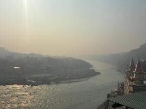 a view of a river with buildings and a city at Om Guesthouse in Rishīkesh +7 photos