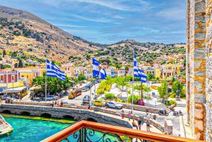 a view of a city with a river and buildings at “Athenas” Neoclassic Harbour View Apartment in Symi