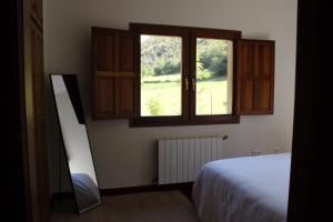 a bedroom with a bed and a window at Los Jazmines de la Vega in La Vega