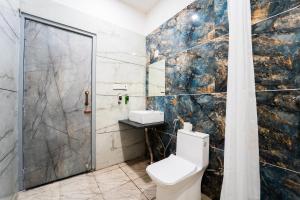 a bathroom with a toilet and a shower at Hotel Aura in Bikaner