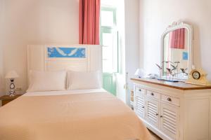 a bedroom with a bed with a mirror and a dresser at “Athenas” Neoclassic Harbour View Apartment in Symi