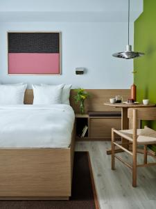 a bedroom with a bed and a table and a chair at Folk Copenhagen in Copenhagen