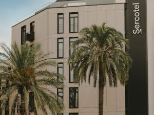 a building with two palm trees in front of it at Sercotel Valencia Ruzafa in Valencia +29 photos