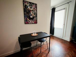 a black table and chairs in a room with a painting at Perle Centers in Dunkerque