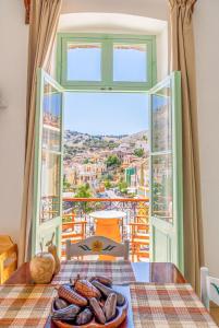 a room with a table with a plate of food and a window at “Athenas” Neoclassic Harbour View Apartment in Symi