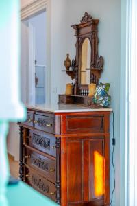 a wooden dresser with a mirror on top of it at “Athenas” Neoclassic Harbour View Apartment in Symi +36 photos