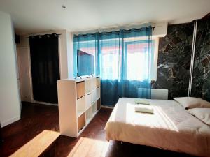 a bedroom with a bed and a large window at Perle Centers in Dunkerque