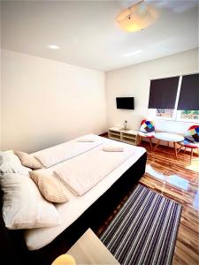 a bedroom with a large bed and a living room at House by the River in Plitvica Selo