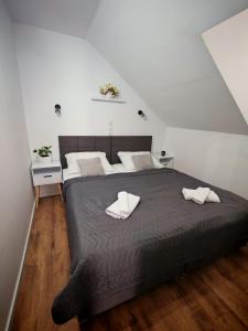 a bedroom with a bed with two white towels on it at Guest House Gacka Rogić in Otočac +131 photos
