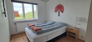 a small room with a bed with a window at Guesthouse Klambrasel in Skogar