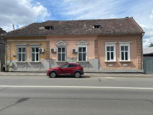a red car parked in front of a building at Apartament Central Salvo in Turda