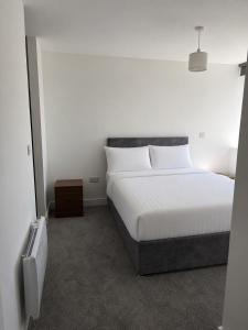 a bedroom with a large white bed and a tv at 505 Broadway residence in Bradford