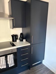 a kitchen with navy blue cabinets and a sink at 505 Broadway residence in Bradford